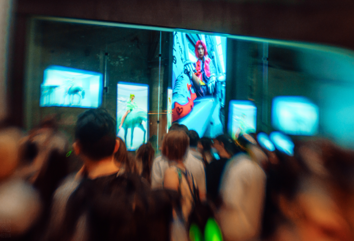 Visitors looking at digital fashion artworks on screens at LOOK 3.0